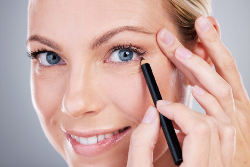 Woman in her early 40s applying eyeliner