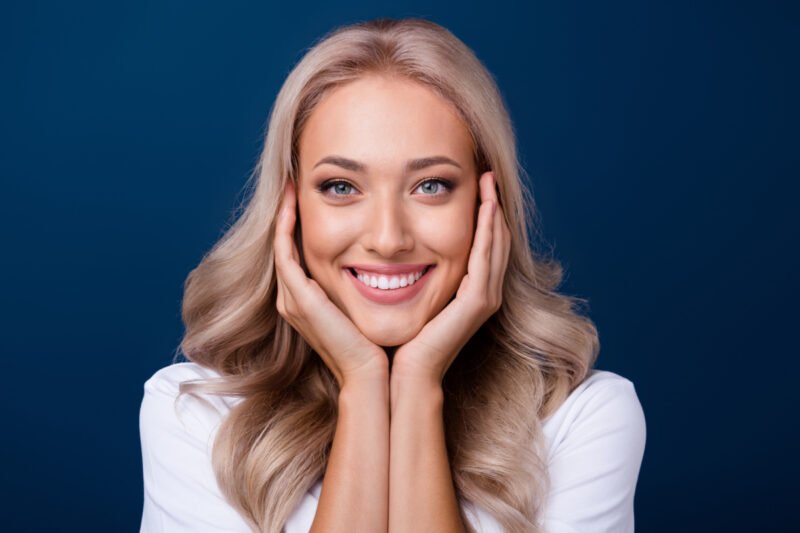 Young woman touching her face and smiling